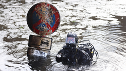 Ein Taucher kann ein Straßenschild im Isebekkanal bergen