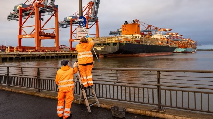 Kolleg:innen in Orange bei der Schilderreinigung