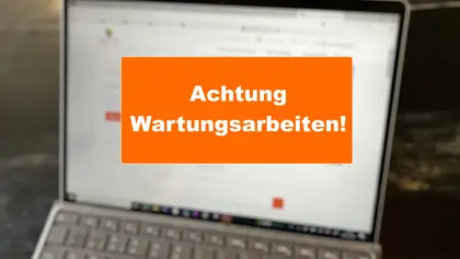 Unscharfer Laptop im Hintergrund. Im Vordergrund der Hinweis "Achtung Wartungsarbeiten!"