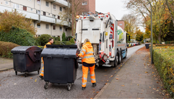 Kolleg:innen in Orange bei der Abfuhr der Restmülltonne
