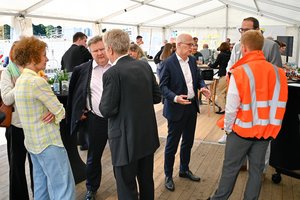 Personen, unter anderem der Bürgermeister beim Besuch auf dem Baustellengelände