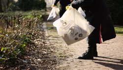 HRA-Teilnehmende räumen mit der Mülltüte auf