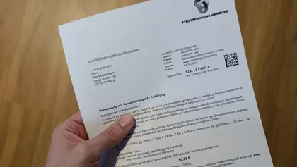 Hand hält Verwarnungsmitteilung