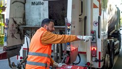 Müllmann an der Schüttung seines Fahrzeugs