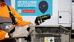 Eine explodierte Lachgaskartusche vor dem Hintergrund eines Motivs der SRH-Kampagne