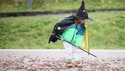 Eine kleine Hexe sammelt Kronkorken auf dem Energieberg auf