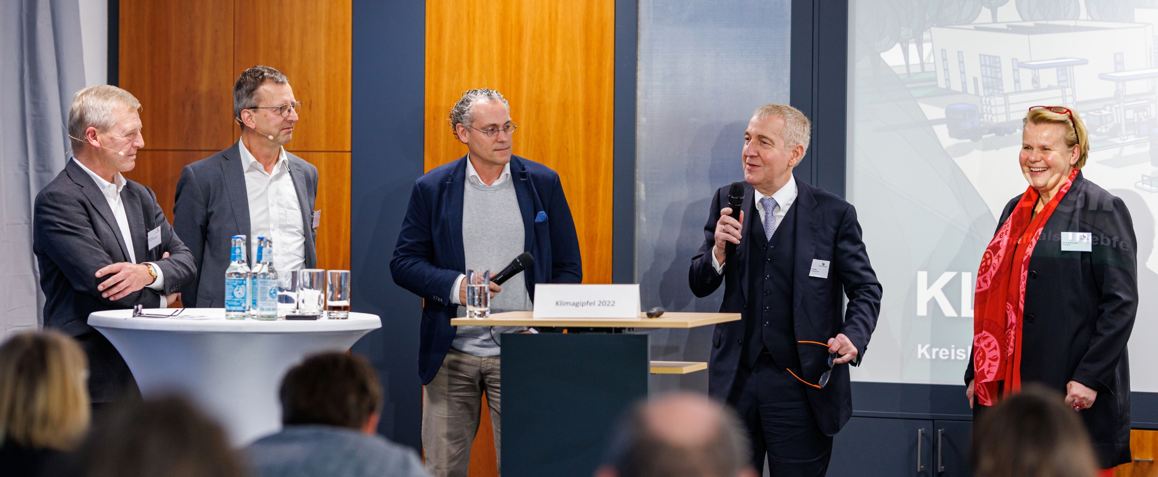 Prof. Dr. Siechau referiert vor einem Publikum. Es stehen vier weitere Personen mit ihm vorne.
