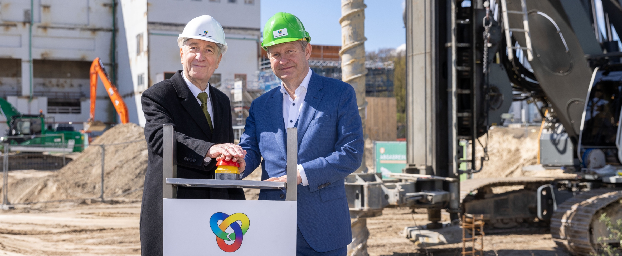Prof. Dr. Siechau und Umweltsenator Jens Kerstan drücken auf der ZRE-Baustelle einen roten Knopf